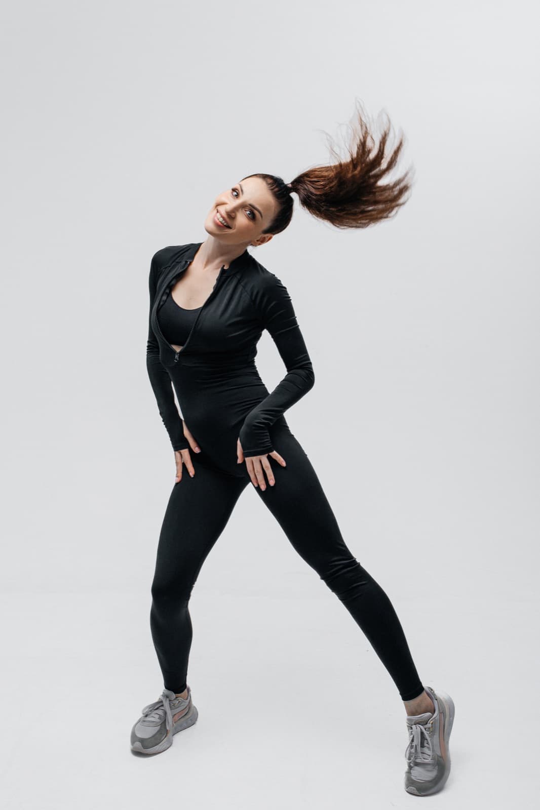 Anastasiia, the Lean Sporty instructor, laughing mid-workout with her hair flying