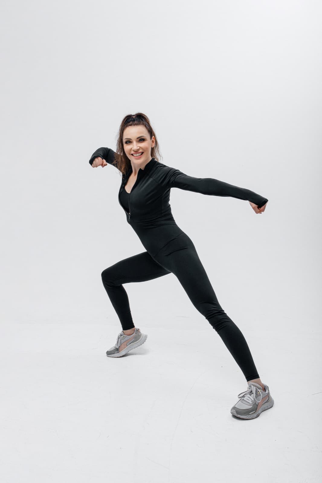 Anastasiia, the Lean Sporty instructor, in a wide lunge with one arm extended