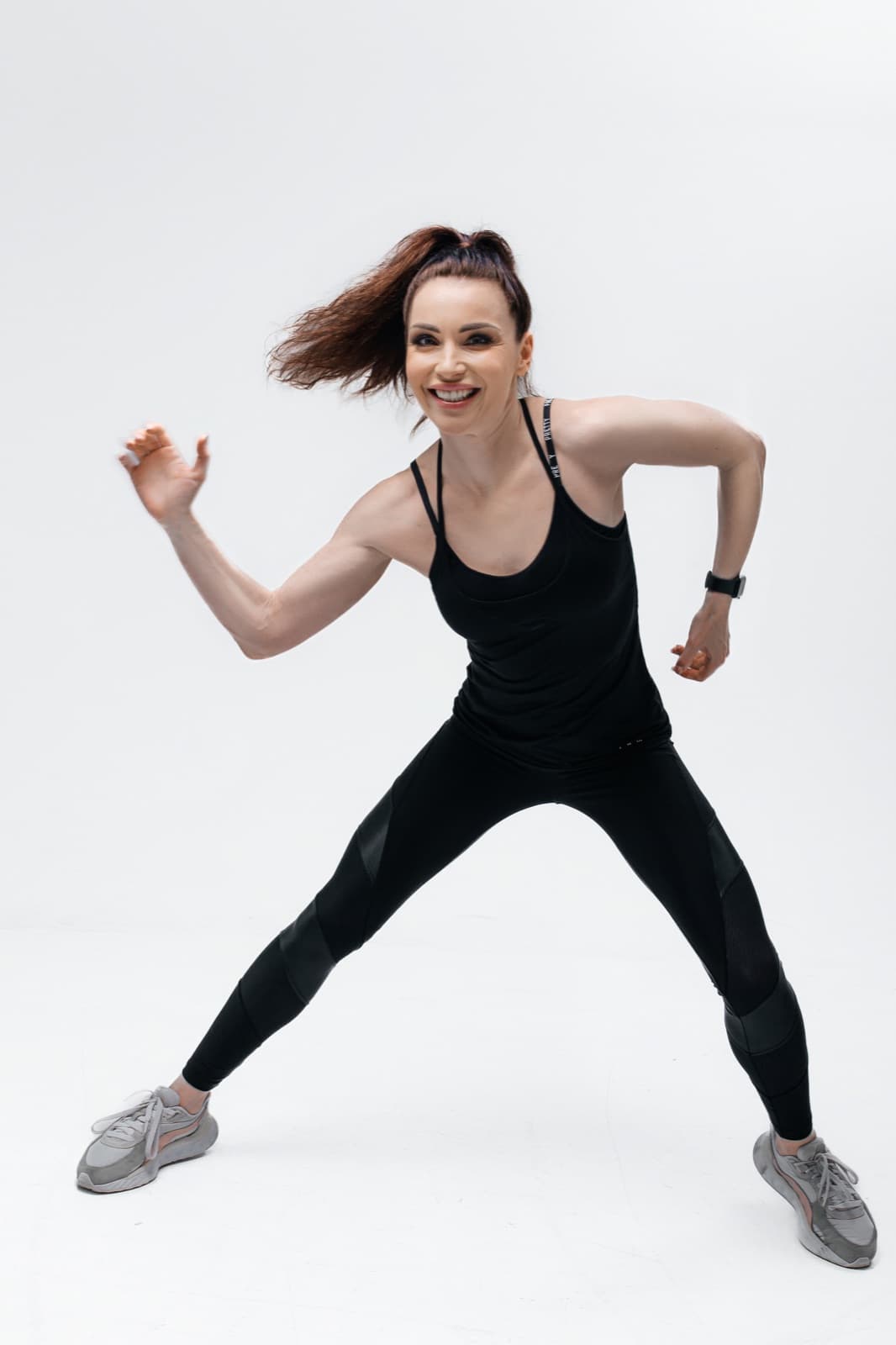 Anastasiia, the Lean Sporty instructor, laughing mid-move in a playful stance
