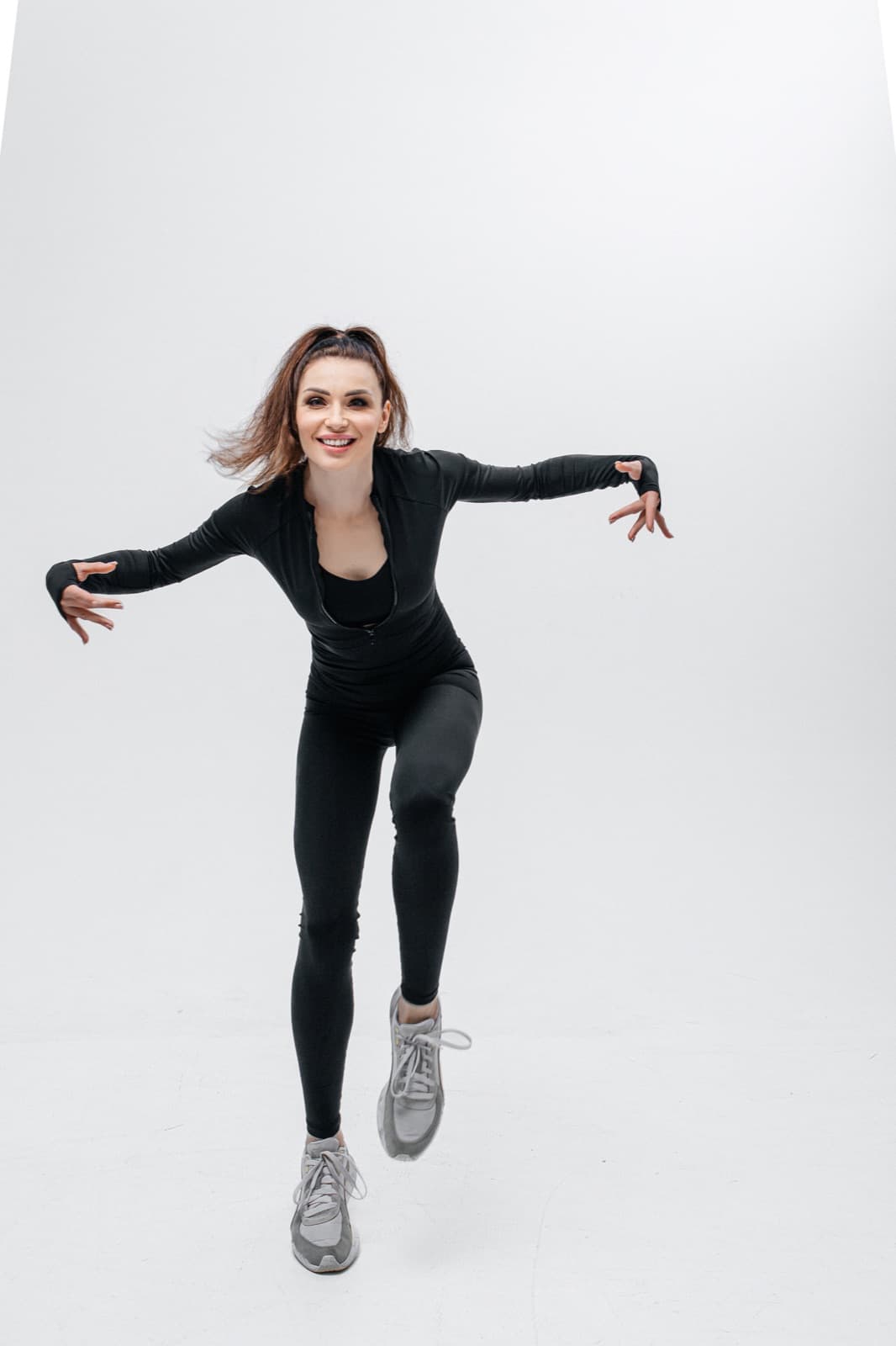 Anastasiia, the Lean Sporty instructor, mid-jump with arms wide